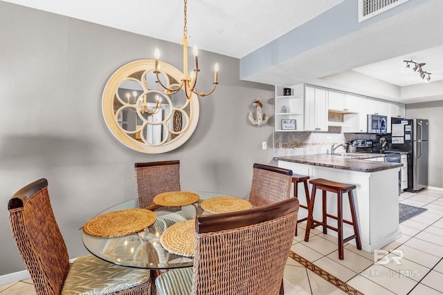 dining space featuring light tile patterned floors, visible vents, track lighting, a chandelier, and baseboards