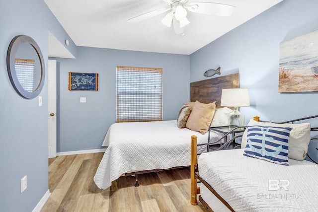 bedroom with ceiling fan, baseboards, and wood finished floors