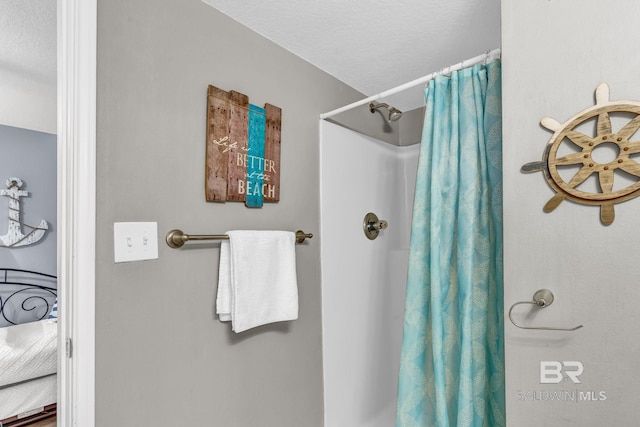 bathroom with a textured ceiling and a shower with shower curtain