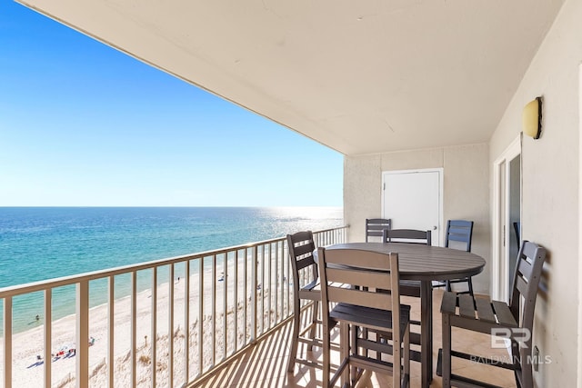 balcony featuring a water view, a view of the beach, and outdoor dining space