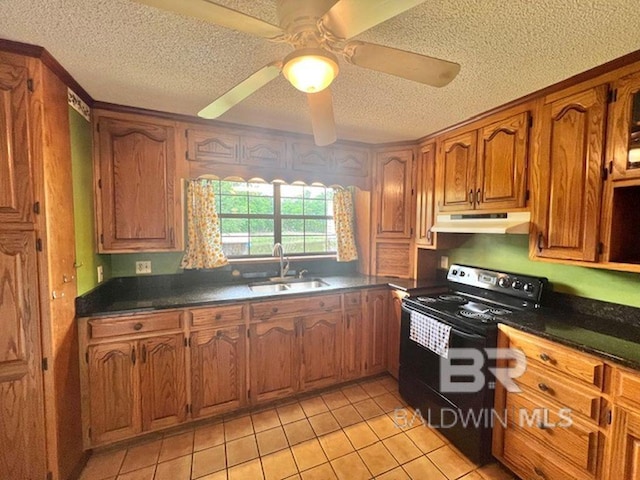 kitchen featuring electric range, a textured ceiling, a sink, under cabinet range hood, and light tile patterned flooring