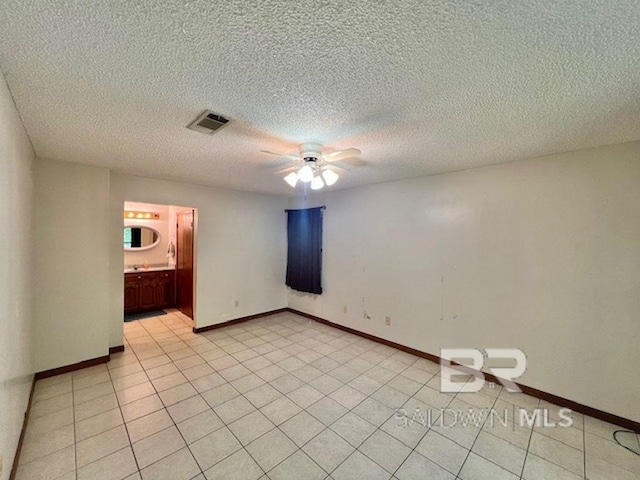 spare room with a ceiling fan, baseboards, visible vents, and light tile patterned flooring