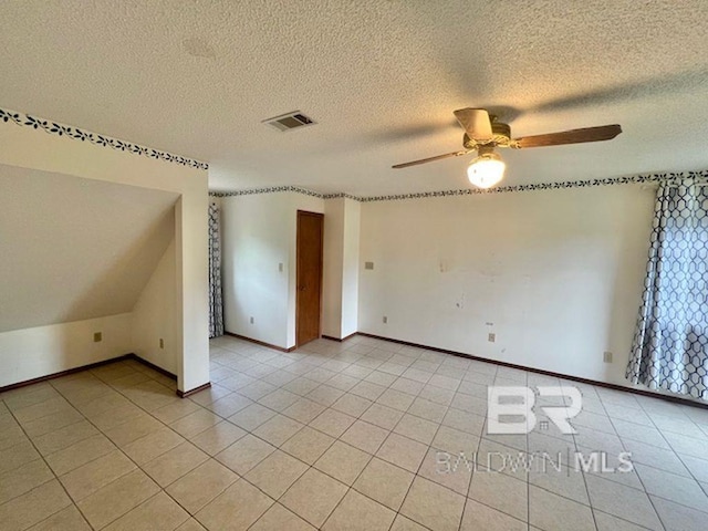 empty room with baseboards, a ceiling fan, a textured ceiling, and visible vents