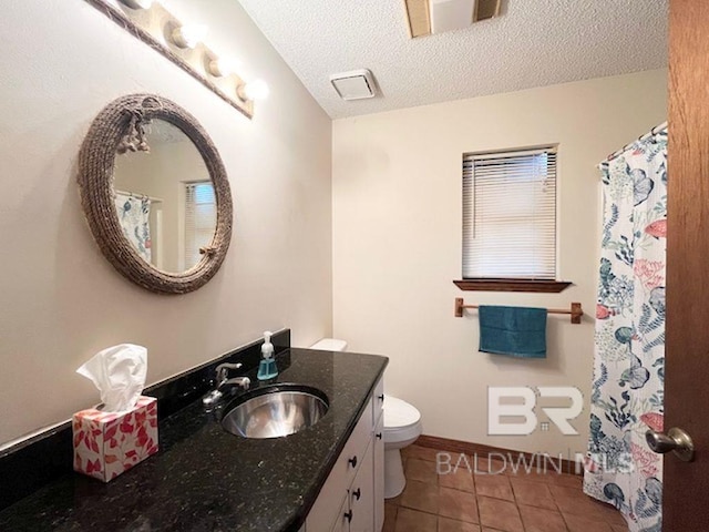 bathroom featuring tile patterned floors, vanity, toilet, and a textured ceiling