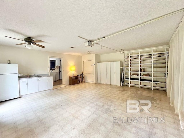 interior space with separate washer and dryer, a textured ceiling, ceiling fan, and tile patterned floors