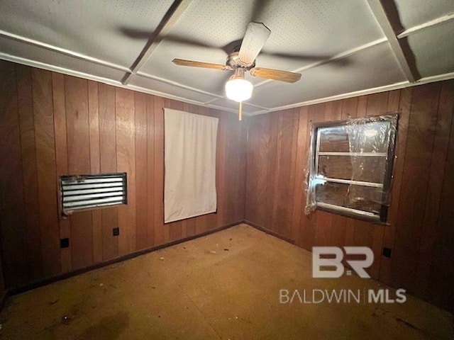 empty room with wooden walls, carpet floors, coffered ceiling, and a ceiling fan