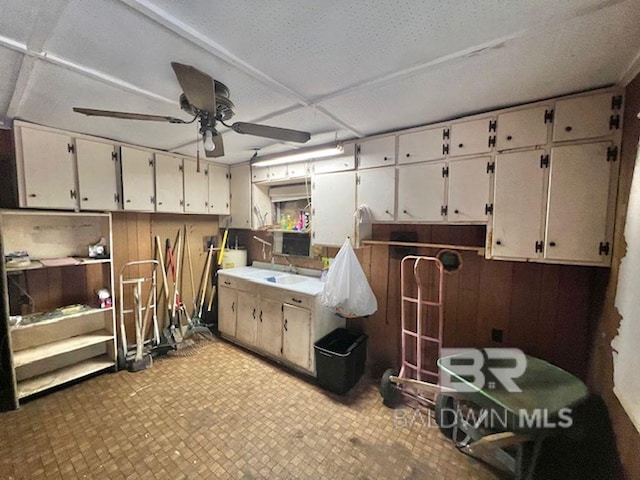 interior space with a ceiling fan, a sink, and tile patterned floors