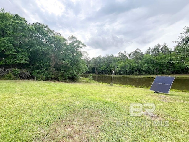 view of yard with a water view and a wooded view