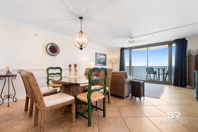 dining area with expansive windows, light tile patterned flooring, crown molding, and a water view