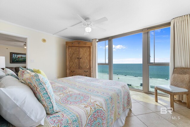 bedroom with light tile patterned floors, a water view, ornamental molding, expansive windows, and access to outside