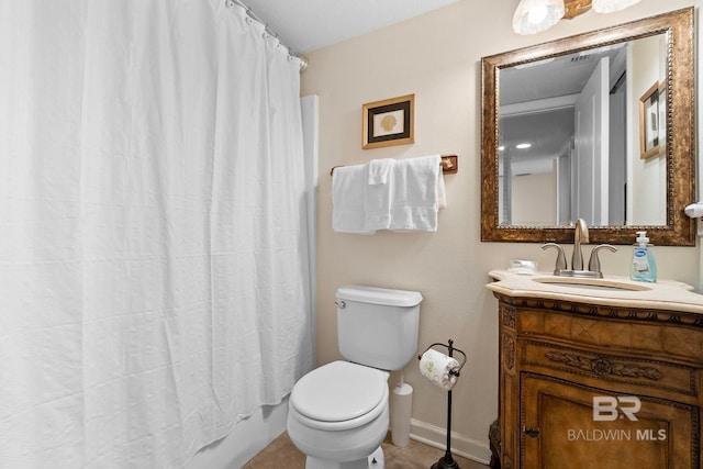 bathroom with toilet, vanity, and baseboards