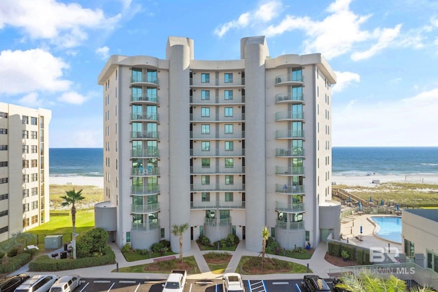 view of building exterior with a water view and a beach view