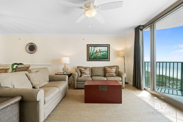 living room featuring light tile patterned floors, a water view, a ceiling fan, ornamental molding, and a wall of windows