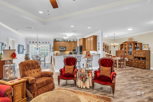 living room featuring ceiling fan with notable chandelier, light hardwood / wood-style floors, and crown molding