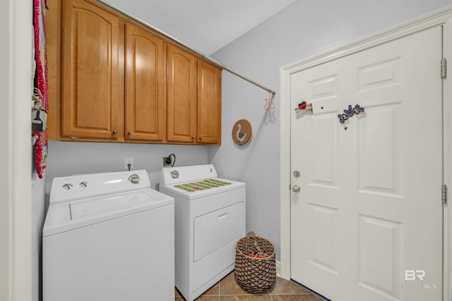 laundry area featuring cabinets, light tile patterned floors, and washing machine and clothes dryer