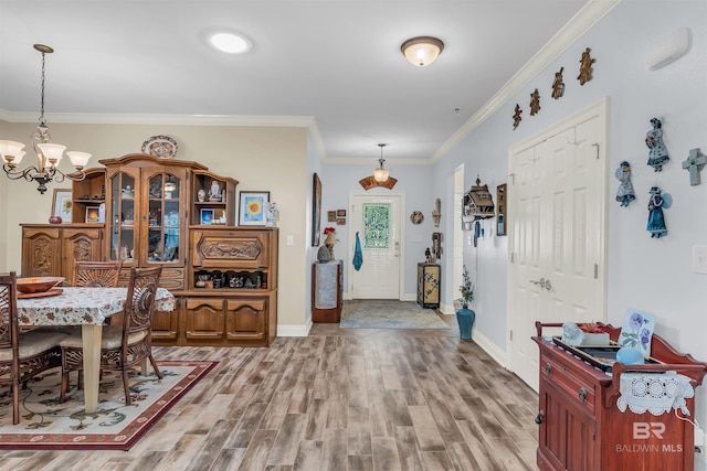 entryway with a chandelier, wood-type flooring, and ornamental molding