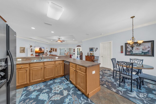 kitchen with kitchen peninsula, appliances with stainless steel finishes, ceiling fan with notable chandelier, sink, and decorative light fixtures