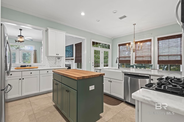 kitchen with white cabinetry, backsplash, appliances with stainless steel finishes, sink, and a center island