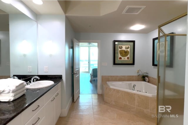 bathroom with a garden tub, vanity, visible vents, and tile patterned floors