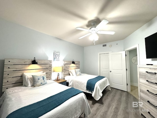 bedroom with ceiling fan, visible vents, and dark wood-type flooring