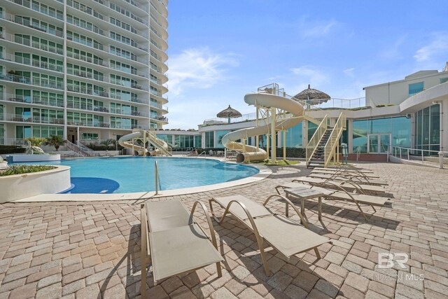 pool with a water slide and a patio area