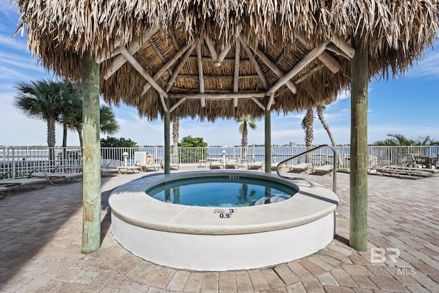 view of swimming pool with a community hot tub, a water view, fence, a gazebo, and a patio area