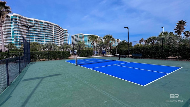 view of sport court with fence and a city view