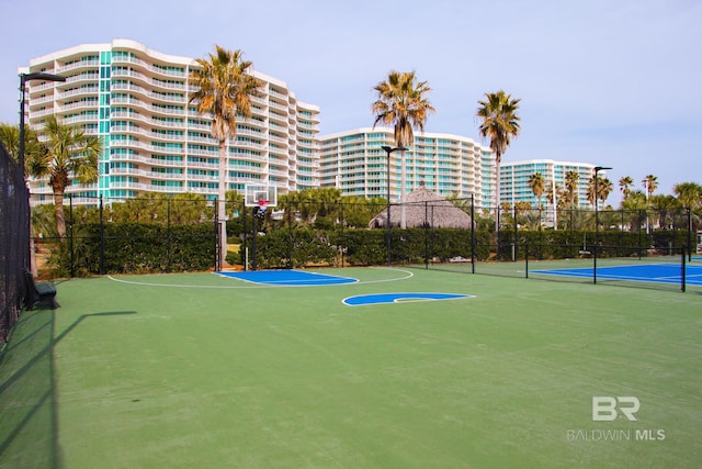 exterior space with community basketball court, a view of city, and fence