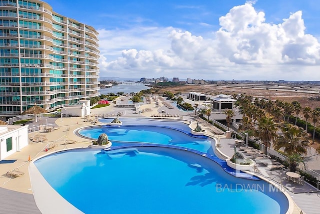 view of pool with a city view and a water view