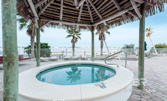 view of swimming pool with a community hot tub, a gazebo, a patio area, and fence