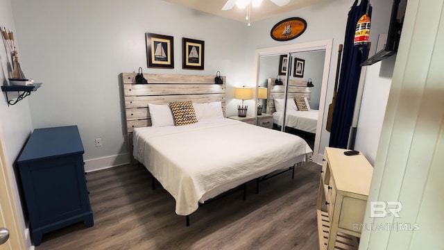 bedroom with dark wood-style floors, ceiling fan, and baseboards