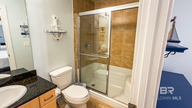 full bath featuring a stall shower, vanity, and toilet