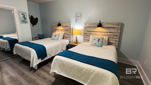 bedroom with baseboards and dark wood-style flooring