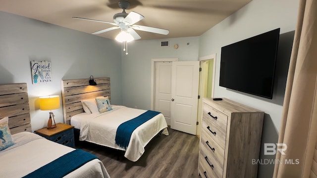 bedroom with dark wood-style floors, ceiling fan, and visible vents