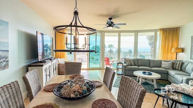 dining area featuring ceiling fan with notable chandelier, light tile patterned flooring, and floor to ceiling windows