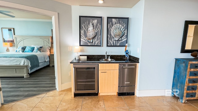 kitchen with wine cooler, open floor plan, light brown cabinets, a sink, and light tile patterned flooring