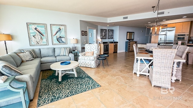 living area featuring beverage cooler, light tile patterned flooring, visible vents, and a notable chandelier