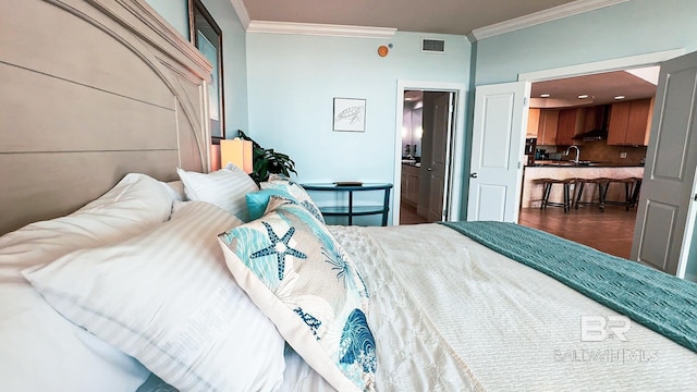 bedroom with ornamental molding, visible vents, and dark tile patterned floors