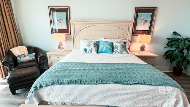 bedroom with wood finished floors and baseboards