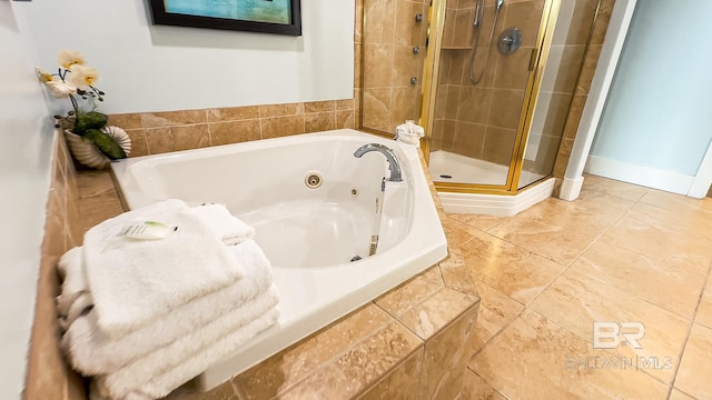 bathroom featuring a whirlpool tub, a shower stall, and baseboards