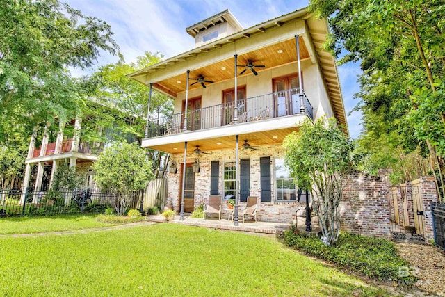 375 S Section St, Fairhope, AL 36532 - back of property with ceiling fan, stucco siding, a lawn, fence, and a balcony