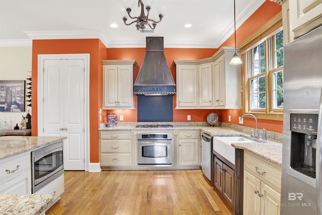 375 S Section St, Fairhope, AL 36532 - kitchen featuring light wood-style flooring, a sink, stainless steel appliances, custom range hood, and a notable chandelier