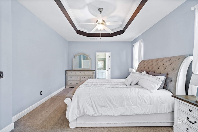 carpeted bedroom featuring ceiling fan, a tray ceiling, and ornamental molding