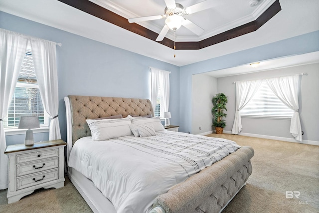 bedroom with light colored carpet, crown molding, ceiling fan, multiple windows, and a tray ceiling