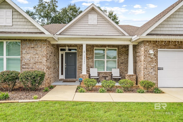 property entrance with covered porch, a yard, and a garage