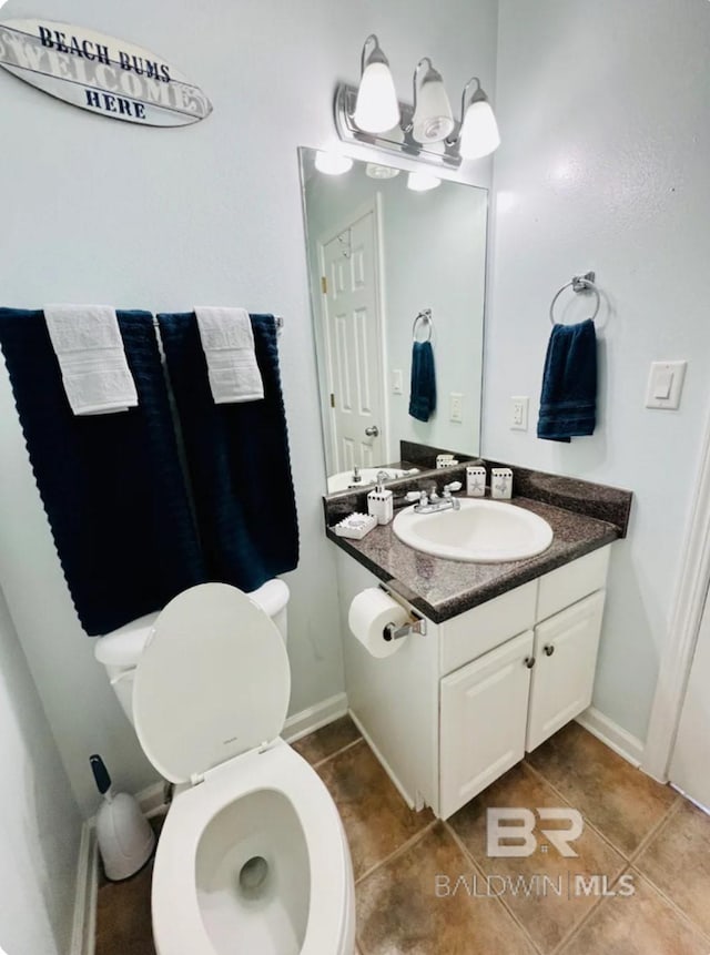 bathroom featuring toilet, tile patterned flooring, and vanity