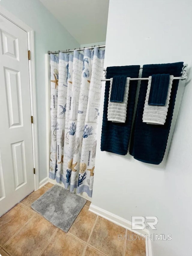 bathroom with walk in shower and tile patterned flooring