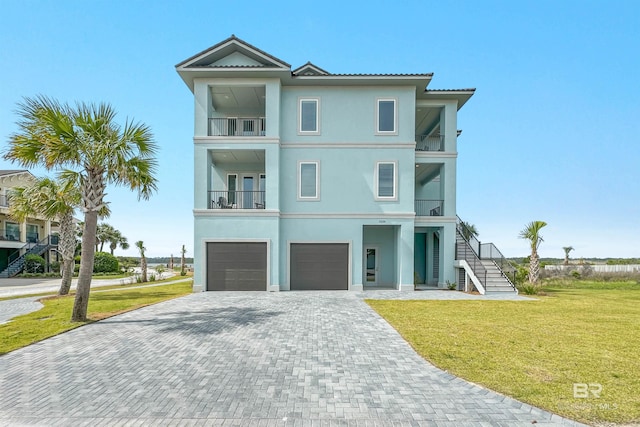 3238 Sea Horse Cir, Gulf Shores, AL 36542 - view of front facade featuring a garage, stairs, stucco siding, and a balcony