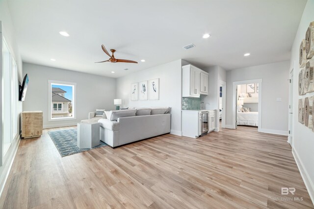 3238 Sea Horse Cir, Gulf Shores, AL 36542 - living room featuring beverage cooler, light wood-style flooring, a ceiling fan, baseboards, and visible vents