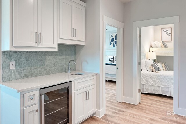 3238 Sea Horse Cir, Gulf Shores, AL 36542 - bar with decorative backsplash, light wood-type flooring, a sink, baseboards, and wine cooler